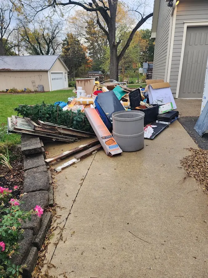 Dumpster being loaded with debris for 12 Yard Dumpster Rental in Wauwatosa